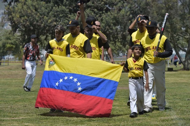 Venezuelan immigrants take part in the inauguration of the Pichincha League Softball Championship, at Parque Bicentenario, in Quito on March 18, 2018. The increase in the number of Venezuelan immigrants in Ecuador leaded to growth of the softball league from four to 16 teams in the last years, with some 450 players in total. / AFP PHOTO / Rodrigo BUENDIA / TO GO WITH AFP STORY BY PAOLA LOPEZ