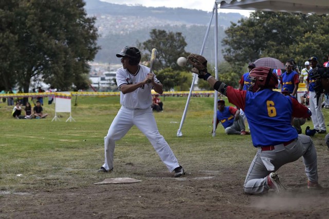 Venezuelan immigrants play softball during the inauguration of the Pichincha League Softball Championship, at Parque Bicentenario, in Quito on March 18, 2018. The increase in the number of Venezuelan immigrants in Ecuador leaded to growth of the softball league from four to 16 teams in the last years, with some 450 players in total. / AFP PHOTO / Rodrigo BUENDIA / TO GO WITH AFP STORY BY PAOLA LOPEZ