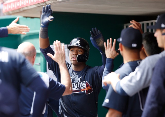 Apr 26, 2018; Cincinnati, OH, USA; Atlanta Braves left fielder Ronald Acuna Jr. (13) is congratulated in the dugout after scoring against the Cincinnati Reds during the eighth inning at Great American Ball Park. Mandatory Credit: David Kohl-USA TODAY Sports