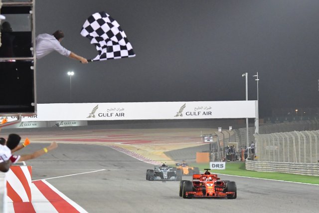 POOL01. Manama (Bahrain), 08/04/2018.- German Formula One driver Sebastian Vettel of Scuderia Ferrari (R) crosses finish line to win the 2018 Formula One Grand Prix of Bahrain at the Sakhir circuit near Manama, Bahrain, 08 April 2018. (Bahrein, Fórmula Uno) EFE/EPA/GIUSEPPE CACACE / POOL