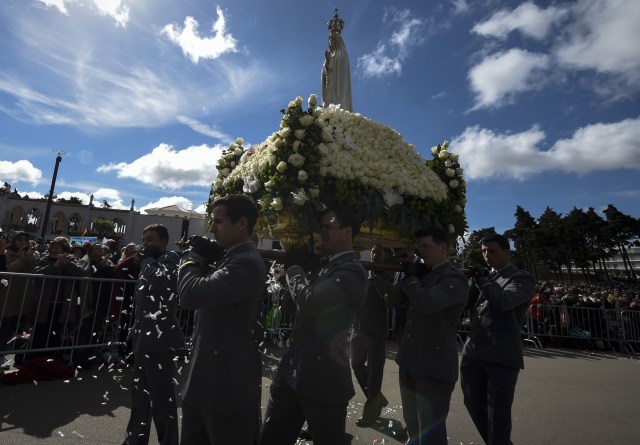 La estatua de Nuestra Señora de Fátima se lleva a cabo durante una ceremonia masiva en el santuario de Fátima en Fátima, en el centro de Portugal, el 13 de mayo de 2018. Miles de peregrinos se reunieron en el Santuario de Fátima para celebrar el aniversario del milagro de Fátima cuando tres niños pastores afirmaron haber visto a la Virgen María en mayo de 1917. / AFP PHOTO / MIGUEL RIOPA