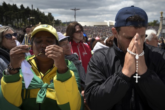 Los peregrinos rezan con rosarios durante una ceremonia masiva en el santuario de Fátima en Fátima, en el centro de Portugal, el 13 de mayo de 2018. Miles de peregrinos se reunieron en el Santuario de Fátima para celebrar el aniversario del milagro de Fátima cuando tres niños pastores afirmaron haber visto a la Virgen María en mayo de 1917. / AFP PHOTO / MIGUEL RIOPA