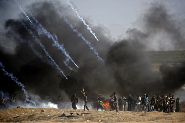  Se lanzaron gases lacrimógenos contra los manifestantes durante los enfrentamientos con las fuerzas israelíes cerca de la frontera entre la Franja de Gaza e Israel, al este de la ciudad de Gaza el 14 de mayo de 2018, tras el controvertido traslado a Jerusalén de la embajada de los Estados Unidos. Cincuenta y dos palestinos fueron asesinados por disparos israelíes durante violentos enfrentamientos en la frontera entre Gaza e Israel coincidiendo con la apertura de la embajada de Estados Unidos en Jerusalén, anunció el ministerio de salud en la franja.Fifty-two Palestinians were killed by Israeli fire during violent clashes on the Gaza-Israel border coinciding with the opening of the US embassy in Jerusalem, the health ministry in the strip announced.  / AFP PHOTO / THOMAS COEX