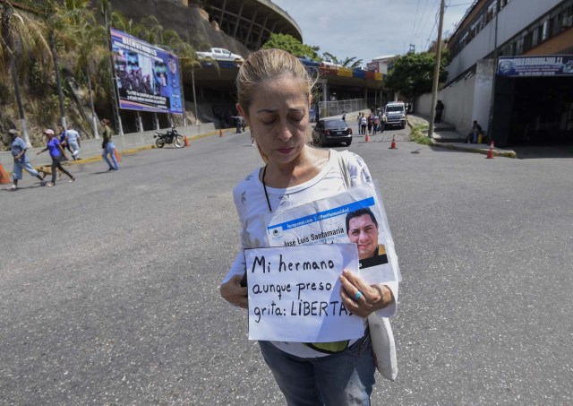 The sister of prisoner Jose Luis Santamaria demonstrates for his release at the entrance of El Helicoide, the headquarters of the Bolivarian National Intelligence Service (SEBIN), in Caracas, on May 17, 2018, where Venezuelan opponents and a US citizen have seized control of the detention centre. The Venezuelan opponents and a US Mormon missionary, who took control of the cell block area on the eve, are demanding the release of prisoners, according to videos broadcast on social networks. / AFP PHOTO / Juan BARRETO