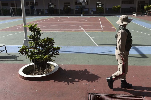 Venezuelan military personnel guard a polling station during the presidential elections in Caracas on May 20, 2018 Venezuelans, reeling under a devastating economic crisis, began voting Sunday in an election boycotted by the opposition and condemned by much of the international community but expected to hand deeply unpopular President Nicolas Maduro a new mandate / AFP PHOTO / Carlos Becerra