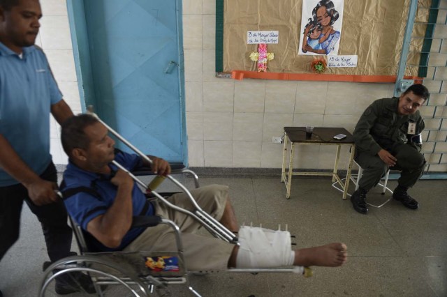 A Venezuelan man is wheeled into a polling station to cast his vote during the presidential elections in Caracas on May 20, 2018 Venezuelans headed to the polls early Sunday to vote in the general elections as incumbent president Nicolas Maduro is seeking a second term in power. / AFP PHOTO / Federico Parra