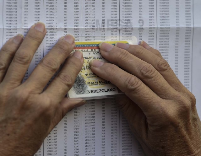 A Venezuelan looks for his names at a polling station before casting his vote during presidential elections in Caracas on May 20 Venezuelans, reeling under a devastating economic crisis, began voting Sunday in an election boycotted by the opposition and condemned by much of the international community but expected to hand deeply unpopular President Nicolas Maduro a new mandate / AFP PHOTO / Juan BARRETO