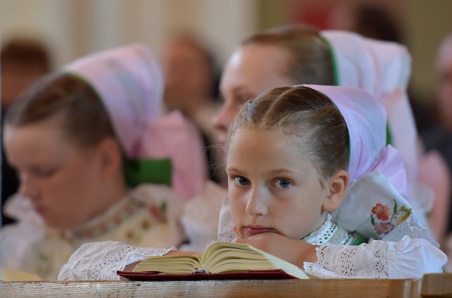 Los Sorb católicos, vestidos con trajes tradicionales, participan en la misa anual de Corpus Christi en Crostwitz, Alemania, el 31 de mayo de 2018. REUTERS / Matthias Rietschel