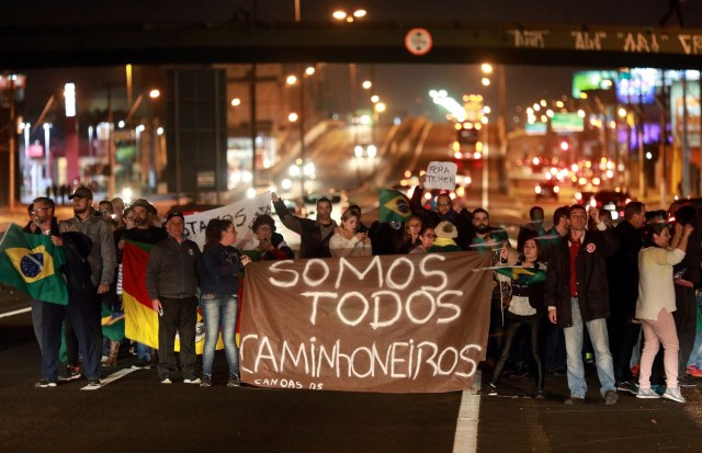 Un grupo de personas asiste a una manifestación en apoyo a la huelga de camioneros en Canoas, Brasil, el 25 de mayo de 2018. El cartel dice "Somos todos camioneros". REUTERS/Diego Vara