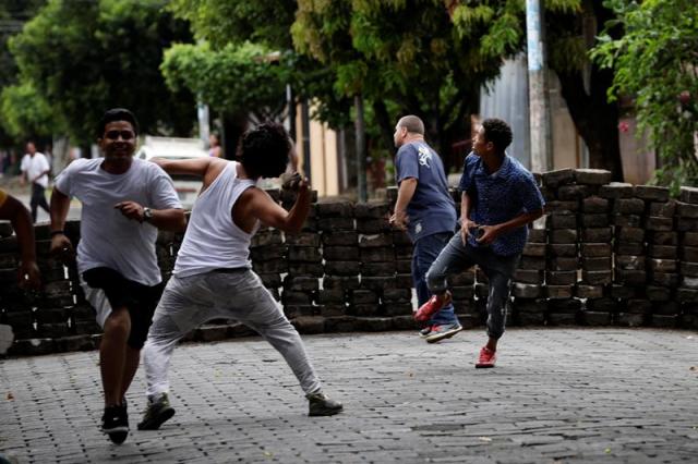 Manifestantes lanzan piedras hoy, 11 de junio de 2018, durante enfrentamientos con la Policia Nacional en los barrios de Managua (Nicaragua). Este lunes por la mañana la Policía Nacional y grupos "parapoliciales" atacaron los llamados "barrios orientales" de Managua con armas de guerra, en respuesta a múltiples barricadas que edificó la población en las calles para impedir el paso de fuerzas de choque oficialistas. EFE/Bienvenido 