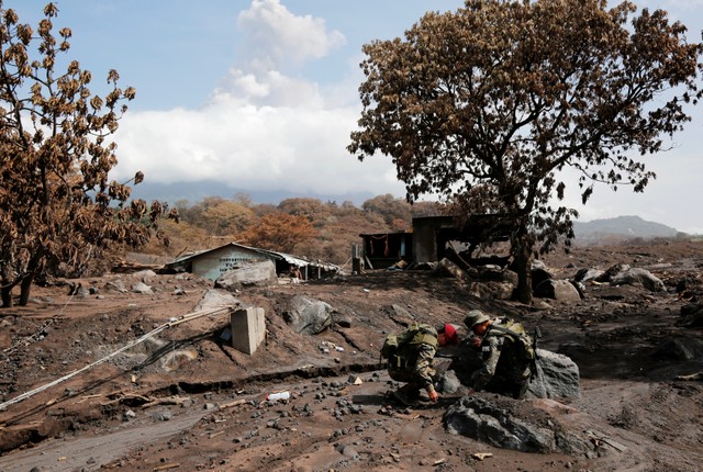 Soldiers check an area affected by the eruption of the Fuego volcano at San Miguel Los Lotes, in Escuintla, Guatemala  June 12, 2018. REUTERS/Luis Echeverria