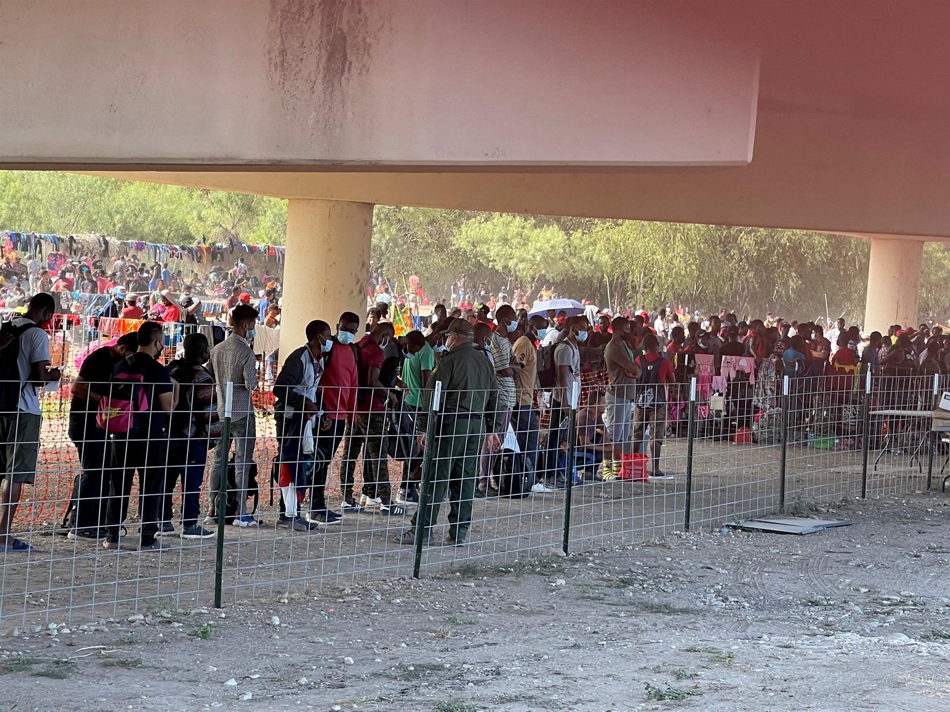 Miles de migrantes acampan bajo un puente en la frontera de EEUU para ser atendidos por la policía