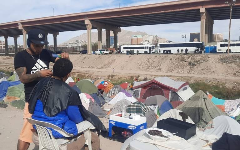 Venezolanos enfrentan la larga espera cortando cabello a orillas del río Bravo